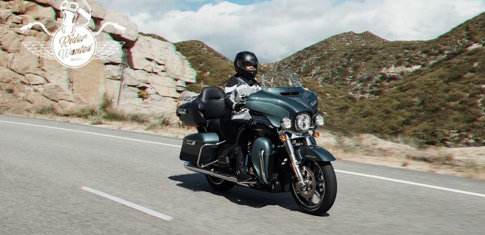 Motociclista pilotando uma moto Harley-Davidson preta em uma estranha rochosa
